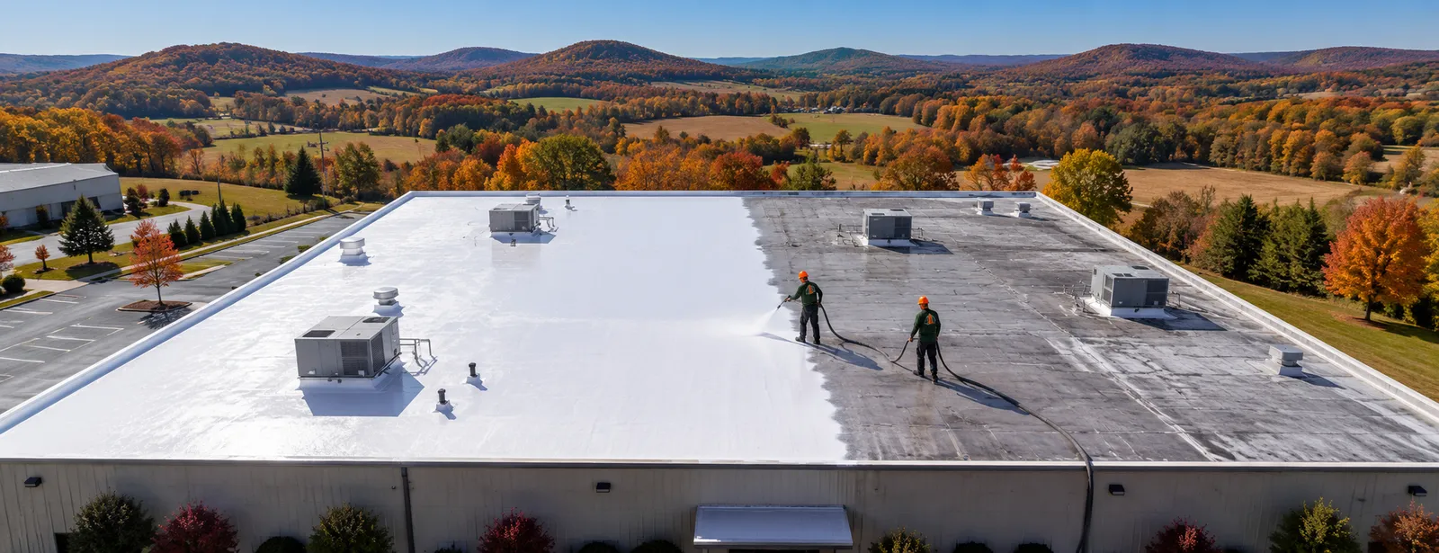 Aerial view of silicone roof coating work on a commercial roof